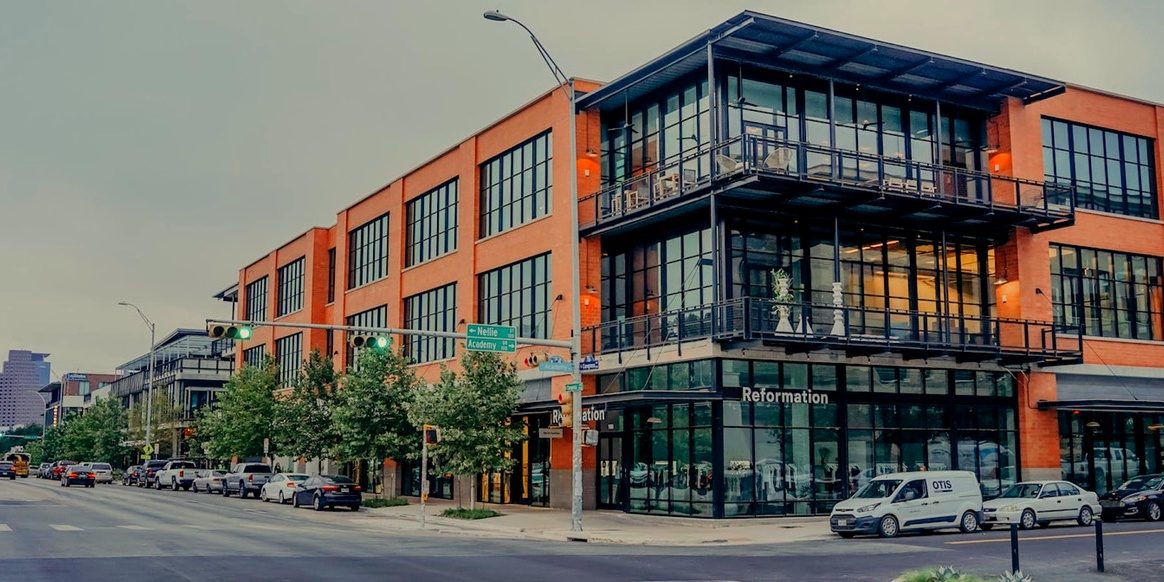Music Lane on South Congress in Austin, Texas: a three-story D'Hanis brick building with black steel windows at a street corner